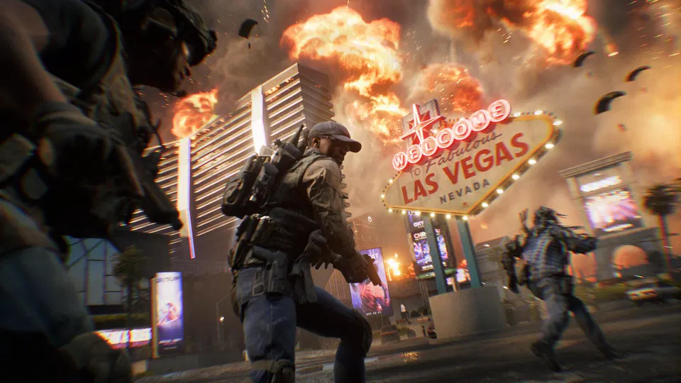 Battlefield 6: voják s kšiltovkou běží ulicí před neonovou cedulí Las Vegas, v pozadí výbuchy.