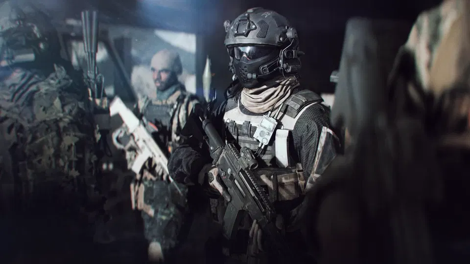 Battlefield 6: vojáci v tmavé výbavě a helmě s plynovou maskou drží útočné pušky v temné místnosti.