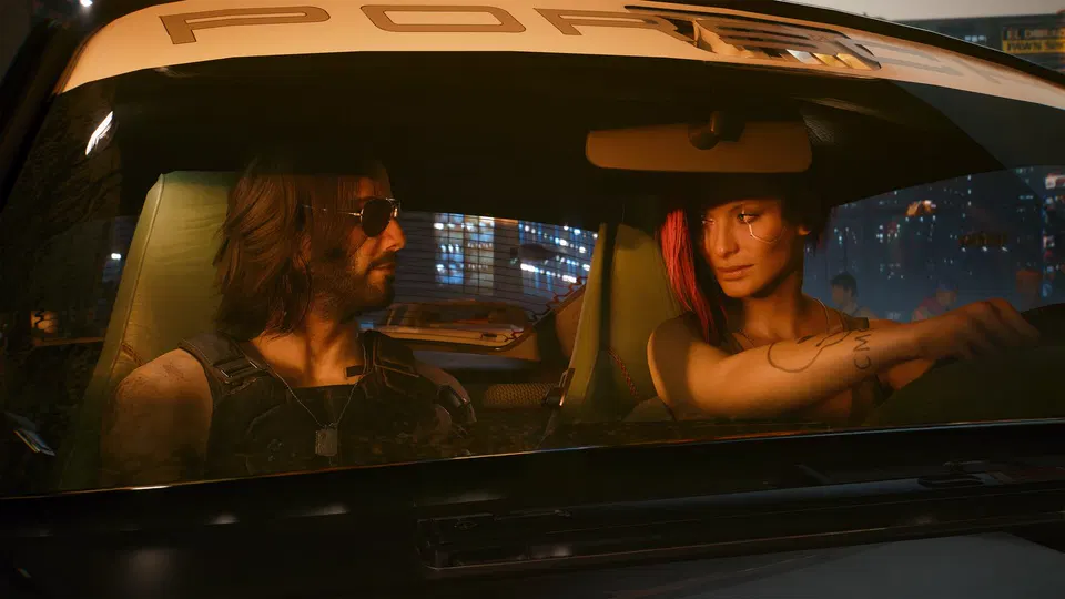 Cyberpunk 2077: V a Johnny Silverhand sedí v autě a dívají se směrem ke stranám, v pozadí noční město.