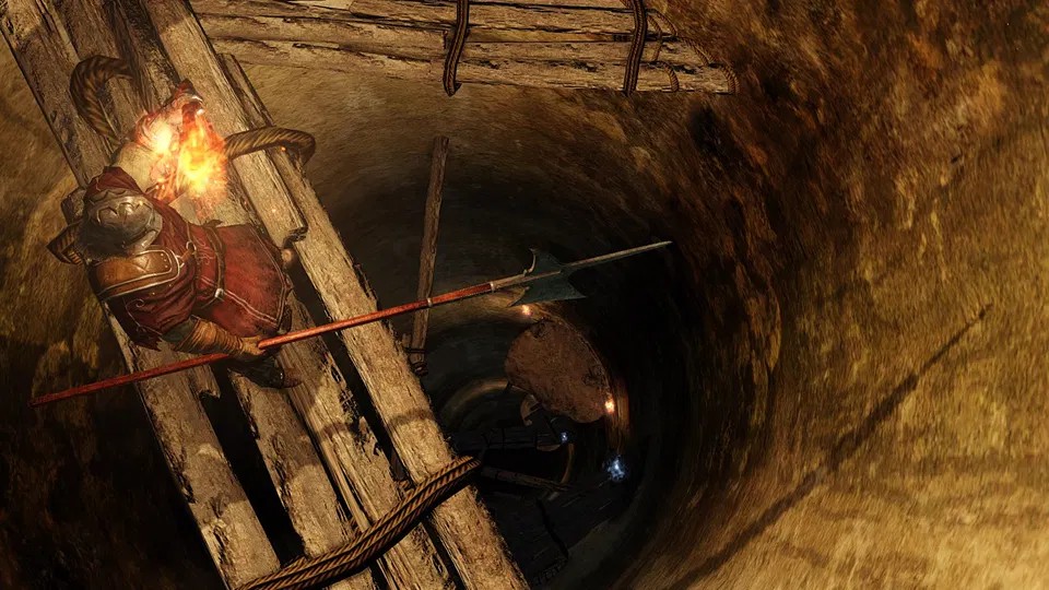 Dark Souls 2: postava s pochodní a kopím stojí na dřevěném žebříku nad hlubokou šachtou