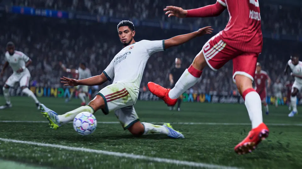 EA Sports FC 27: hráč v bílém dresu se v záklonu snaží zablokovat míč na trávníku před soupeřem v červeném.