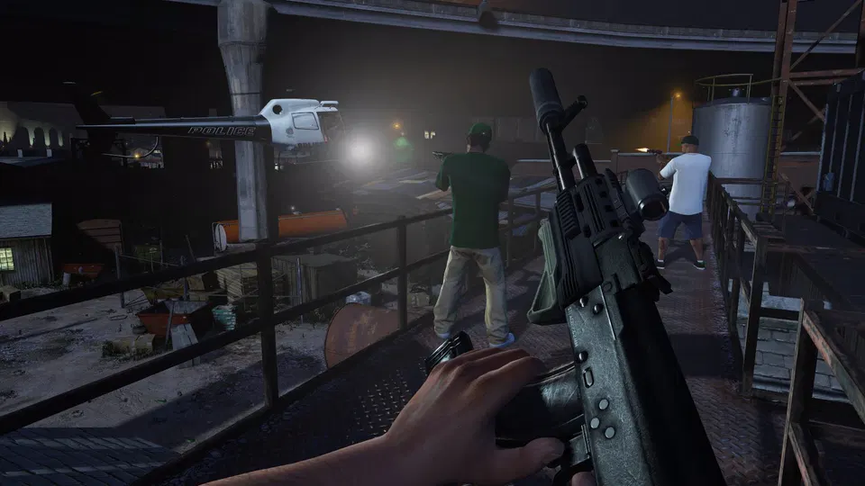 GTA 5: postava z pohledu první osoby míří puškou na muže v zeleném tričku na noční průmyslové ploše.