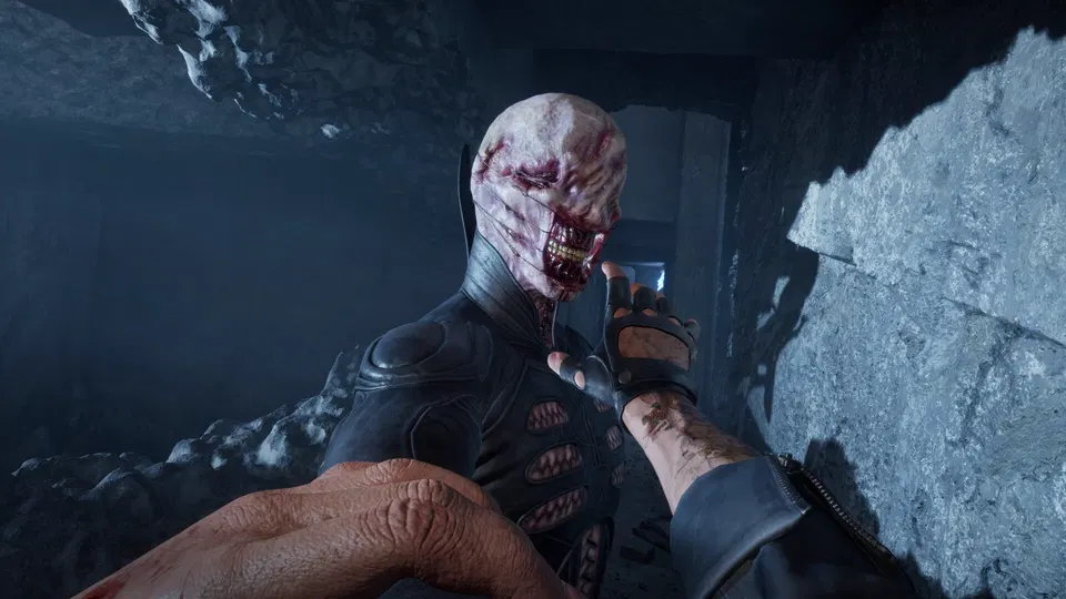 Clive Barker's Hellraiser: Revival – bledý tvor s otevřenými ústy v tmavé kamenné chodbě, pohled z první osoby