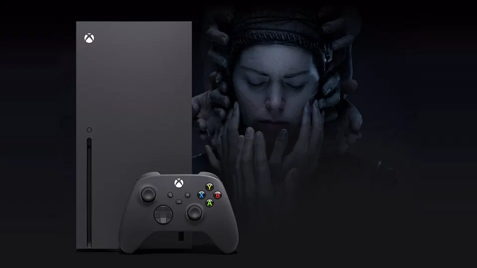 Ilustrační obrázek: Černý Xbox Series X s ovladačem, za nimi temná postava Senuy z Hellblade II; tmavé pozadí do stran rozšířené kvůli formátu 16:9